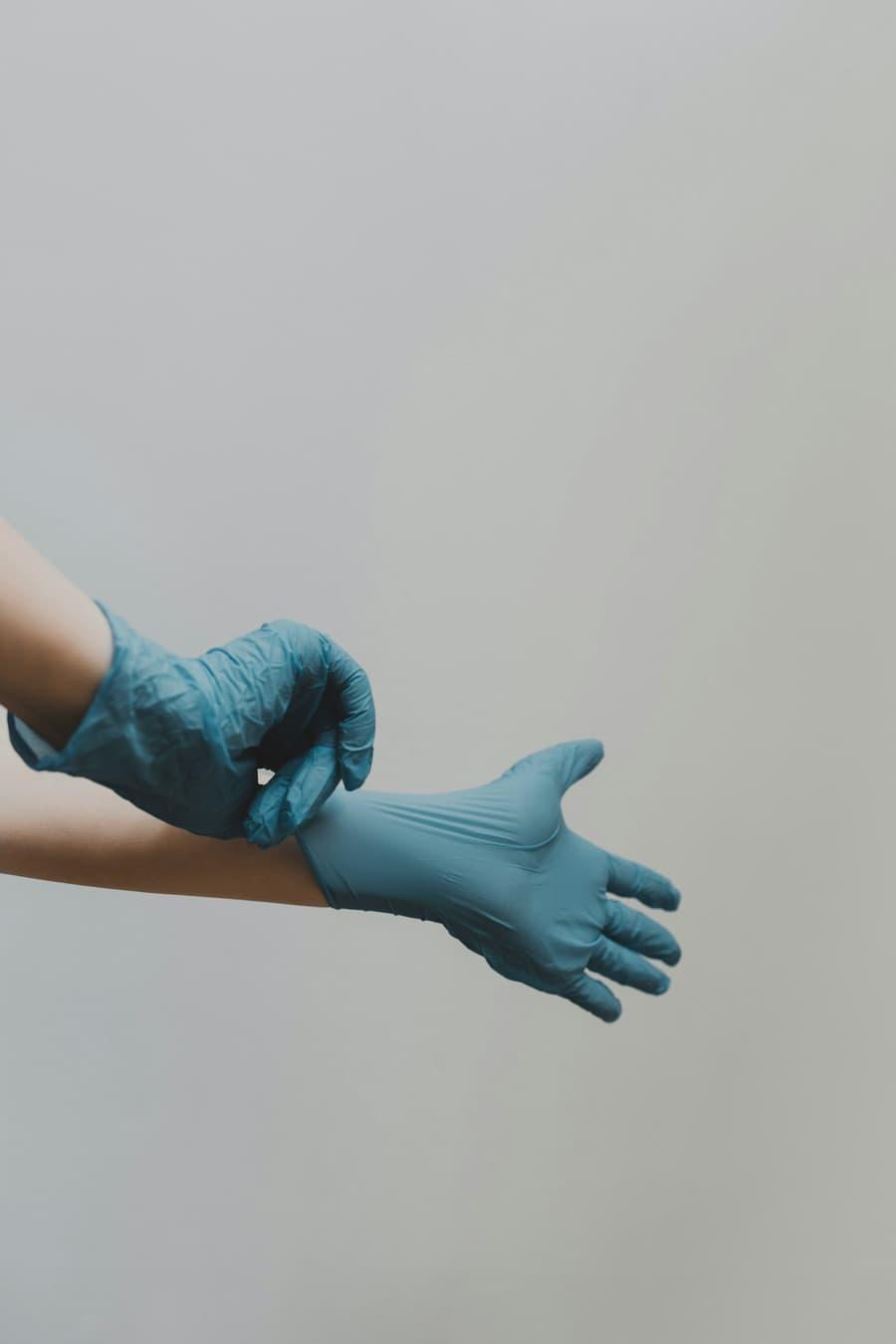 Healthcare worker putting on protective medical gloves